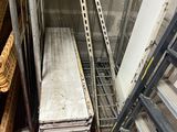 a stack of metal shelves in a warehouse next to a ladder