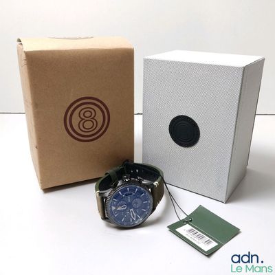 a watch sitting next to a box with a tag on it
