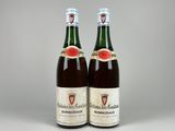 two bottles of wine sitting next to each other on a table