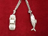 une voiture en argent et un pendentif en forme de poisson suspendu à une chaîne
