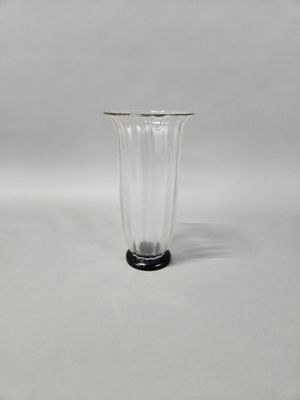 a clear glass vase with a black base on a white background