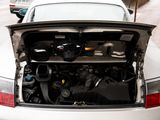 a white car with its hood open on the street