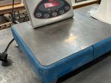 une image représentant une balance installée sur un tapis roulant dans une usine