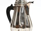 cafetière plaquée argent avec une poignée noire sur un fond blanc