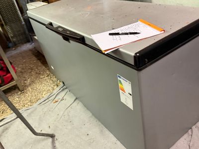 a silver refrigerator with a notepad on top of it
