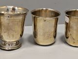 quatre tasses en argent sont alignées sur une table