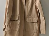 the coat is hanging on a hanger on the wall