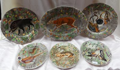 plusieurs assiettes sur lesquelles sont peints des animaux et des oiseaux, posées sur une table