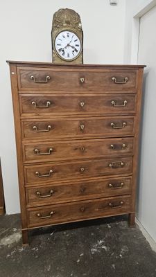 une commode en bois surmontée d'une horloge