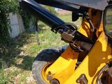 a close up of a yellow tractor with a black handle
