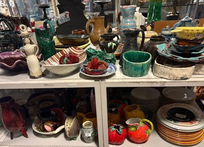de nombreux bols et assiettes sur une étagère dans un magasin