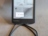 un Kindle branché à un chargeur posé sur la table