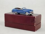 une petite voiture bleue posée sur une boîte rouge
