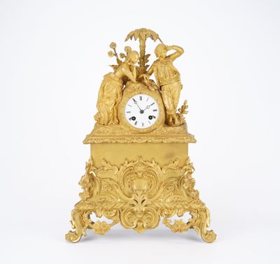 a gold clock that is sitting on top of a table