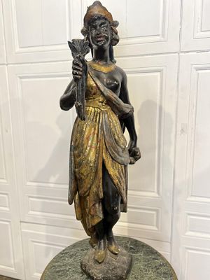 statue en bronze représentant une femme tenant un oiseau, posée sur un socle en marbre