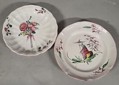 two plates with flowers and birds on them sitting on a table