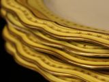 several gold plates stacked on top of each other on a black surface