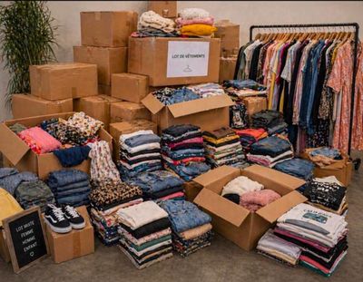 un gros tas de vêtements et de cartons dans une pièce