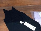 a black tank top and a white shirt on a wooden floor