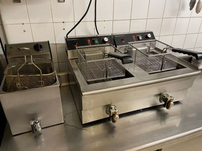two deep fryers sitting on a counter in a kitchen