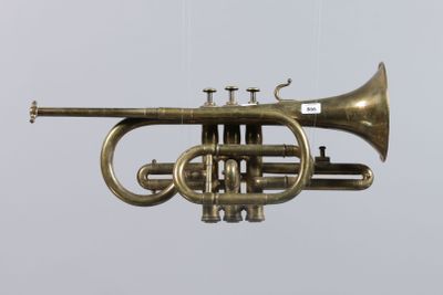 a brass trumpet hanging from the ceiling in a room