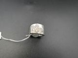 une bague en argent sertie d'un diamant, posée sur une surface noire