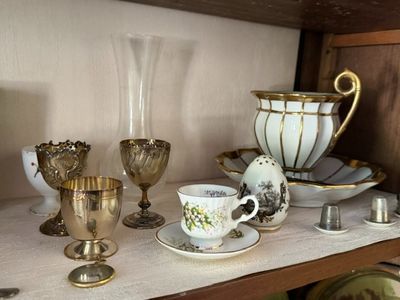 a shelf that has a bunch of cups and saucers on it