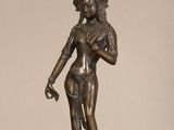 bronze statue of a woman holding a bird on a table