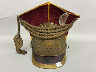 un chapeau doré orné d'un ruban rouge sur le dessus