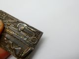 une personne tenant un petit objet métallique dans la main