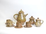 a group of tea pots and cups sitting on a table