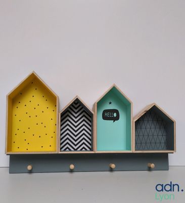 une étagère sur laquelle sont posées trois maisons de couleurs différentes