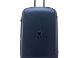 La valise bleue repose sur ses roulettes, posée sur une surface blanche.