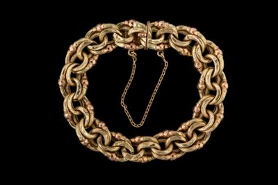 gros plan d'un bracelet en chaîne en or sur fond noir