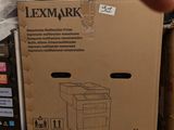 une personne montrant du doigt un carton contenant une imprimante, posé sur une palette