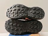 the soles of a pair of black hiking shoes on top of a cardboard box