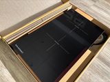 an open box with a laptop inside of it on a wooden floor