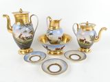quatre objets différents en porcelaine et en or posés sur la table