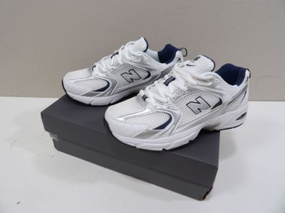 white new balance shoes with blue accents on display on a black box
