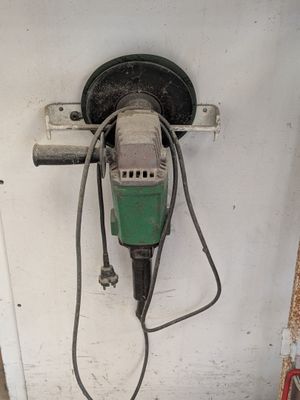 une perceuse accrochée au mur à côté d'une porte