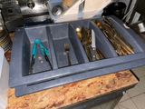 knives, spoons, and utensils are in a tray on a counter