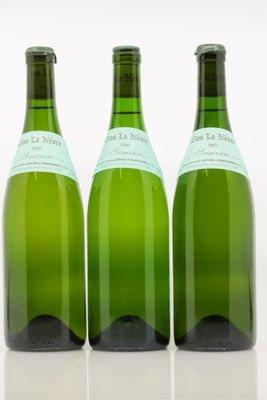 trois bouteilles de vin posées les unes à côté des autres sur une surface blanche