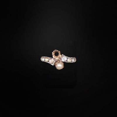un gros plan d'une bague ornée d'une perle et de diamants