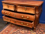 a wooden dresser with three drawers and a rug on the floor