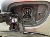 a close up of a car ' s rear view mirror with a car plugged in