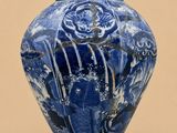 un vase bleu et blanc posé sur une surface beige clair