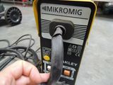 a hand that is holding an electric device in a garage