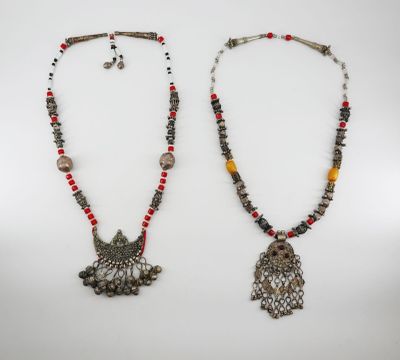a pair of necklaces with beads and charms on them