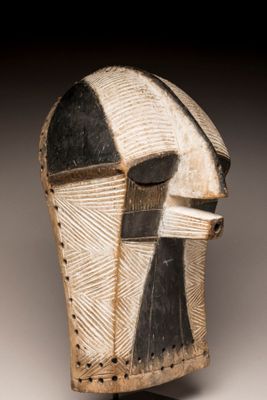 un gros plan d'un masque en bois orné d'un motif en noir et blanc