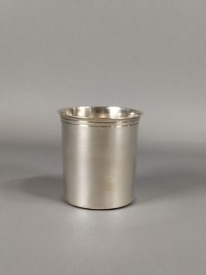 gros plan d'une coupe en argent sur une surface blanche